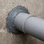 Rura przechodząca przez ścianę z widocznym uszczelnieniem